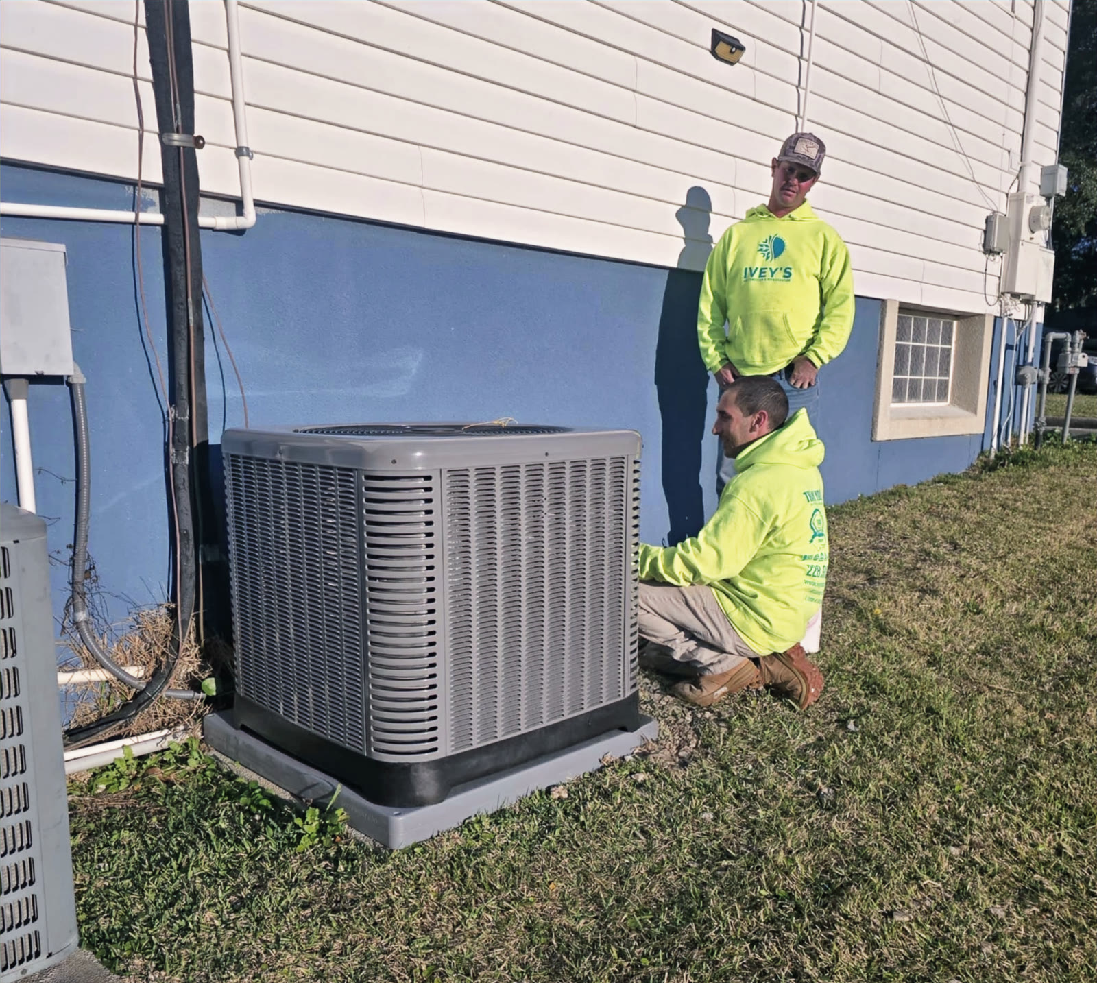 Ivey's technicians Chris and Chad completing a new air conditioner condenser installation